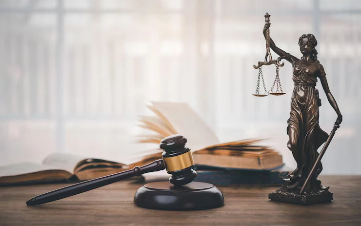Richterhammer, Justitia-Statue und juristische Dokumente – Symbolbild für IT für Kanzleien.